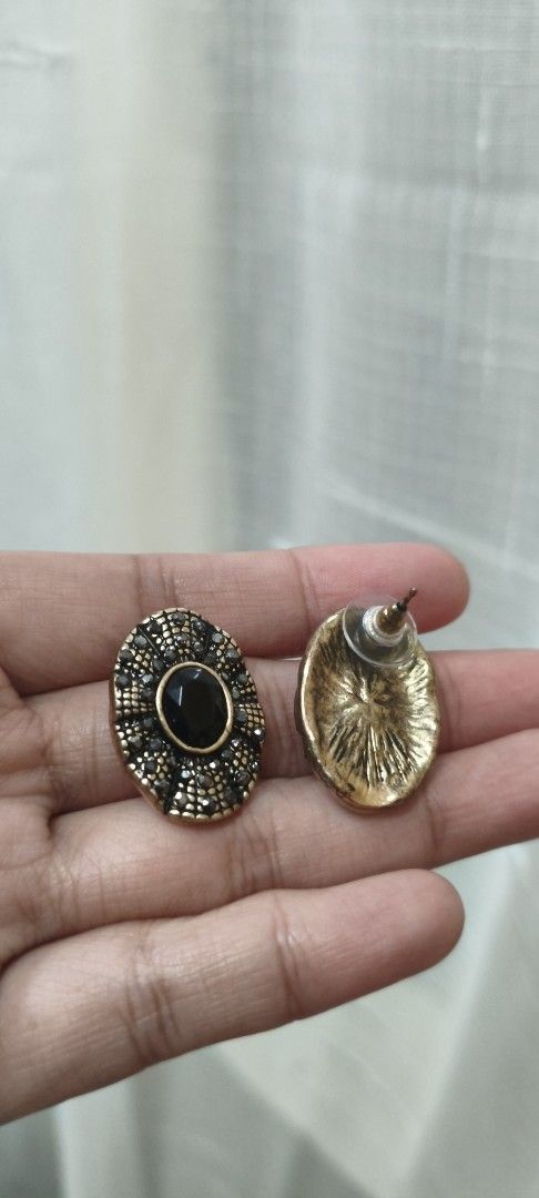 Vintage Style Black Stone Stud Earrings (Category: Earrings) located in Quezon City. Submitted by gemaicloset (Listing ID 1463202586, Image 2). Description: - Oval-shaped earrings - Black center stone - Surrounded by smaller dark stones - Textured gold-tone metal setting - Vintage/antique aesthetic - Standard post and butterfly backing - Ideal for making a statement.