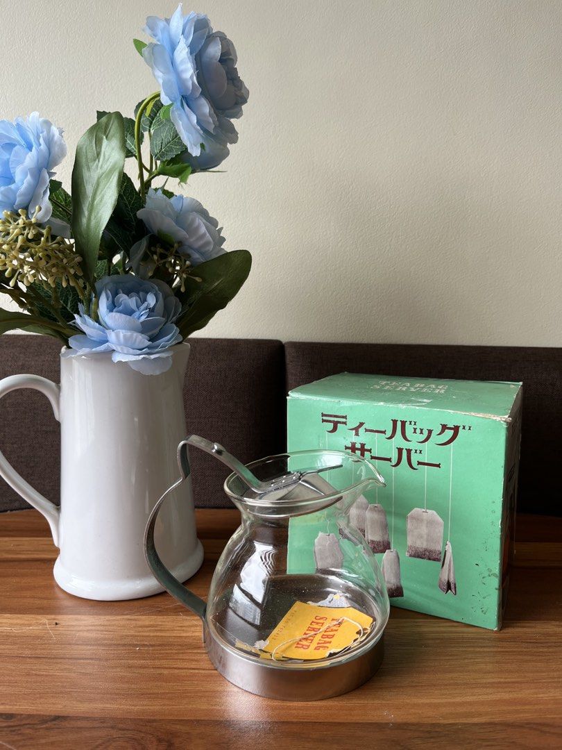 Vintage Tea Bag Server Glass Pitcher with Box (Category: Coffee & Tea Tableware) located in Caloocan City. Submitted by happypenguin-808164 (Listing ID 1463220751, Image 2). Description: - Glass tea bag server - Stainless steel base - Comes with original box - Box shows some wear - Perfect for serving tea bags - Unique kitchenware item.