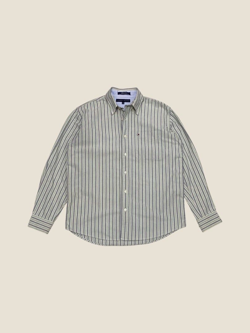 Vintage Tommy Hilfiger Multi-Striped Button-Down Shirt (Category: Formal Shirts) located in Santa Rosa. Submitted by revive.n.thrive (Listing ID 1463303901, Image 1). Description: A refined, high-grade vintage essential. Features an elegant muted green, navy, and cream vertical stripe pattern constructed from a premium, soft-touch cotton weave. Embodying an effortless preppy vibe and a quiet luxury aesthetic, this piece is finished with a sharp b