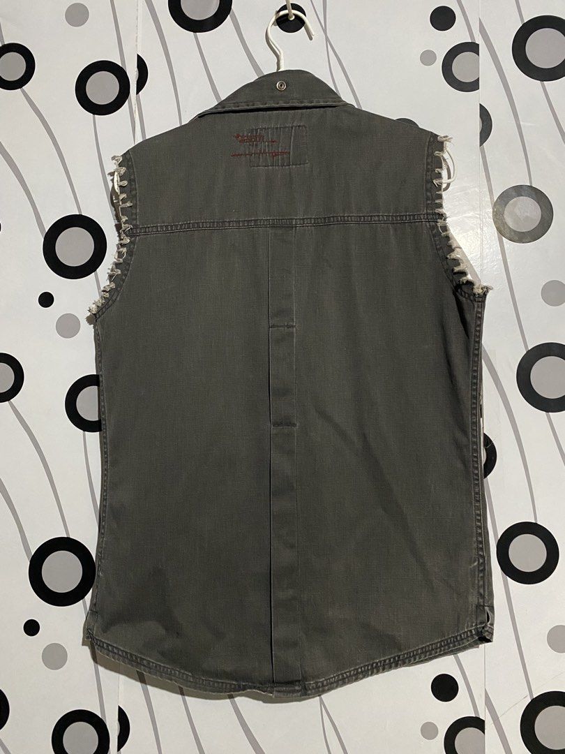 Vintage Tough Jeansmith sleeveless (Category: Tshirts & Polo Shirts ) located in Cebu City. Submitted by patspickph (Listing ID 1463261601, Image 2). Description: This is a vintage Tough Jeansmith sleeveless military-style or utility button-down shirt, likely from the Y2K era. Features the distinctive "Tough Jeansmith Emergency Note" collar and neck branding tag. **Details: Dark charcoal grey cotton fabric, snap buttons, a chest pocket with a sta