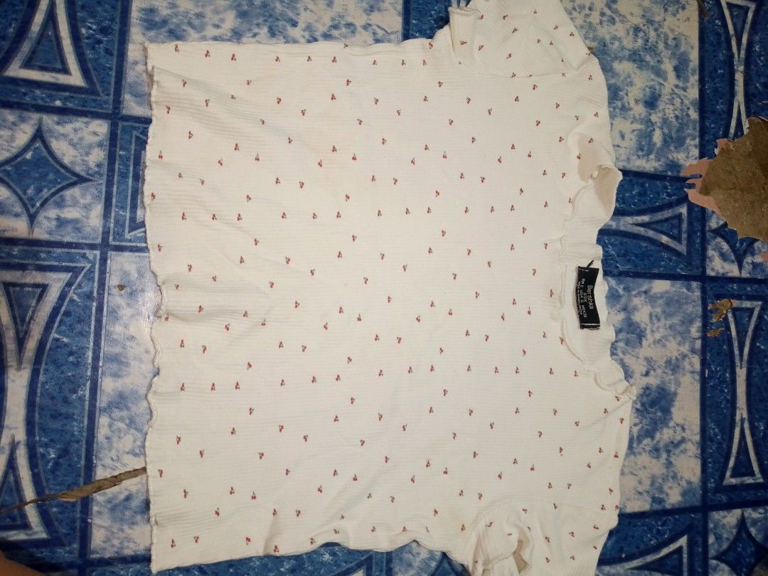 White Cropped T-shirt with Red Cherry Print (Category: Blouses) located in Manila. Submitted by aeshieballl (Listing ID 1463239209, Image 1). Description: - Adorable white cropped t-shirt - Features a fun all-over red cherry print - Trendy ribbed texture - Cute lettuce hem on sleeves and bottom edge - Estimated size: Small to Medium - Ideal for everyday casual wear.