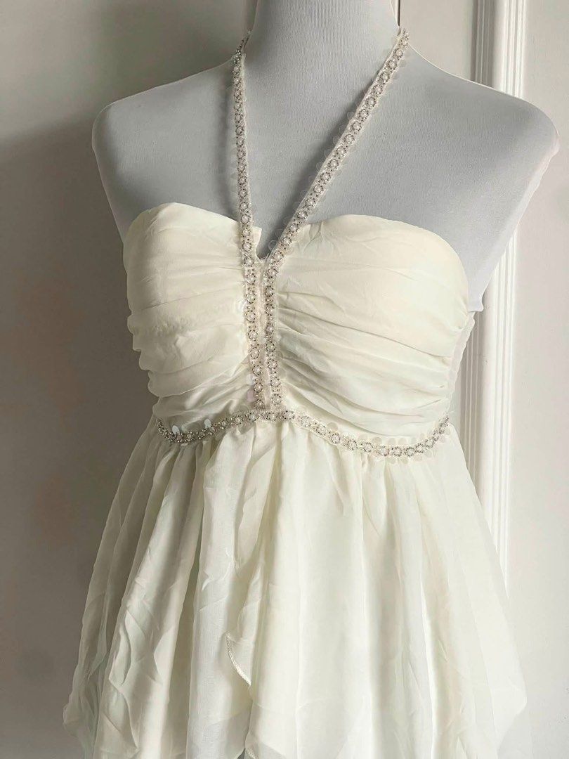 White Halter Top with Rhinestone Embellishments (Category: Sleeveless) located in Cavite. Submitted by devilourea (Listing ID 1463257280, Image 2). Description: - White halter top - Sweetheart neckline - Ruched bodice with rhinestone trim - Asymmetrical hemline with flowy chiffon overlay - Beaded strap ties at the neck - Ideal for parties or a night out.