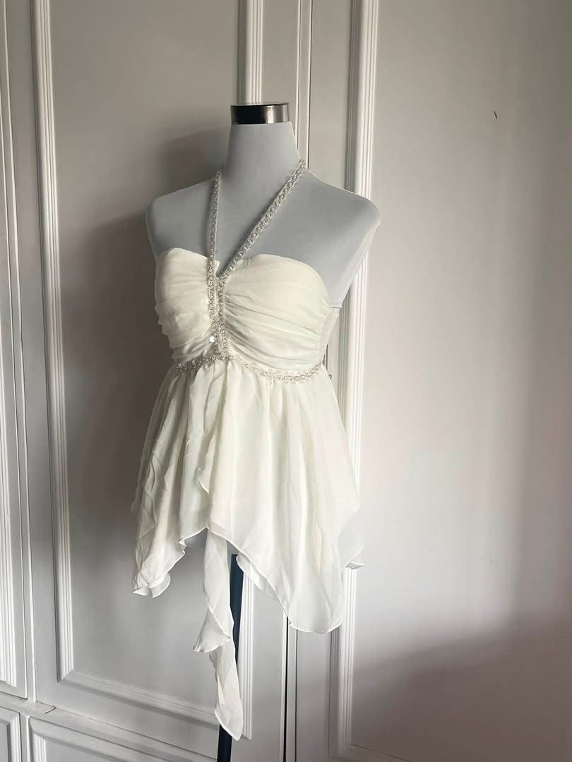 White Halter Top with Rhinestone Embellishments (Category: Sleeveless) located in Cavite. Submitted by devilourea (Listing ID 1463257280, Image 1). Description: - White halter top - Sweetheart neckline - Ruched bodice with rhinestone trim - Asymmetrical hemline with flowy chiffon overlay - Beaded strap ties at the neck - Ideal for parties or a night out.