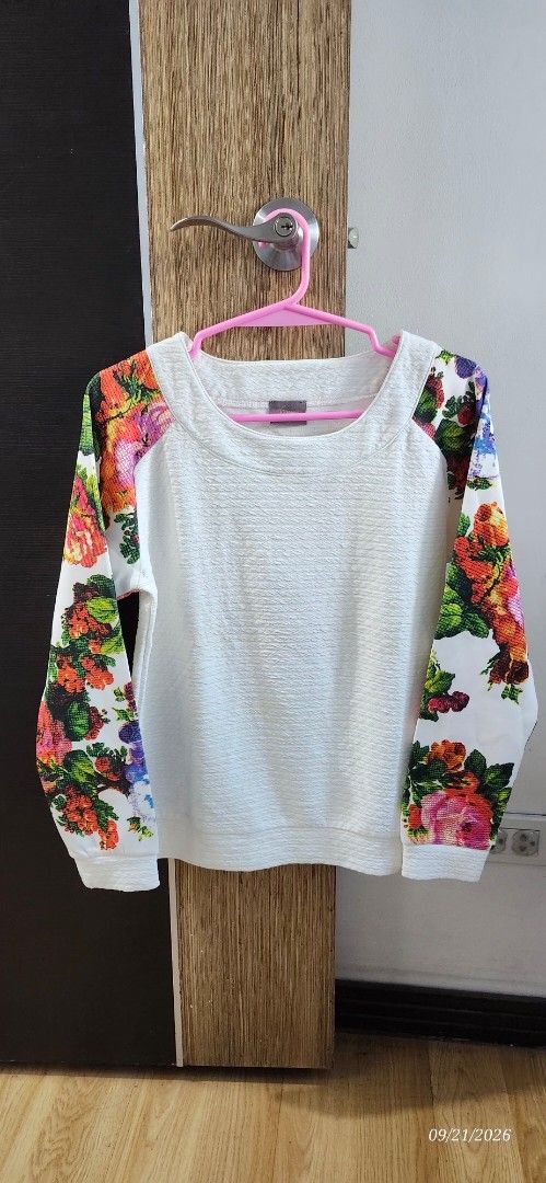White Textured Sweater with Floral Sleeves (Category: Longsleeves) located in Manila. Submitted by atan2025 (Listing ID 1463216423, Image 1). Description: - White textured long-sleeved sweater - Vibrant floral print sleeves with roses and colorful flowers - Comfortable round neckline - Stylish piece for adding a pop of color.