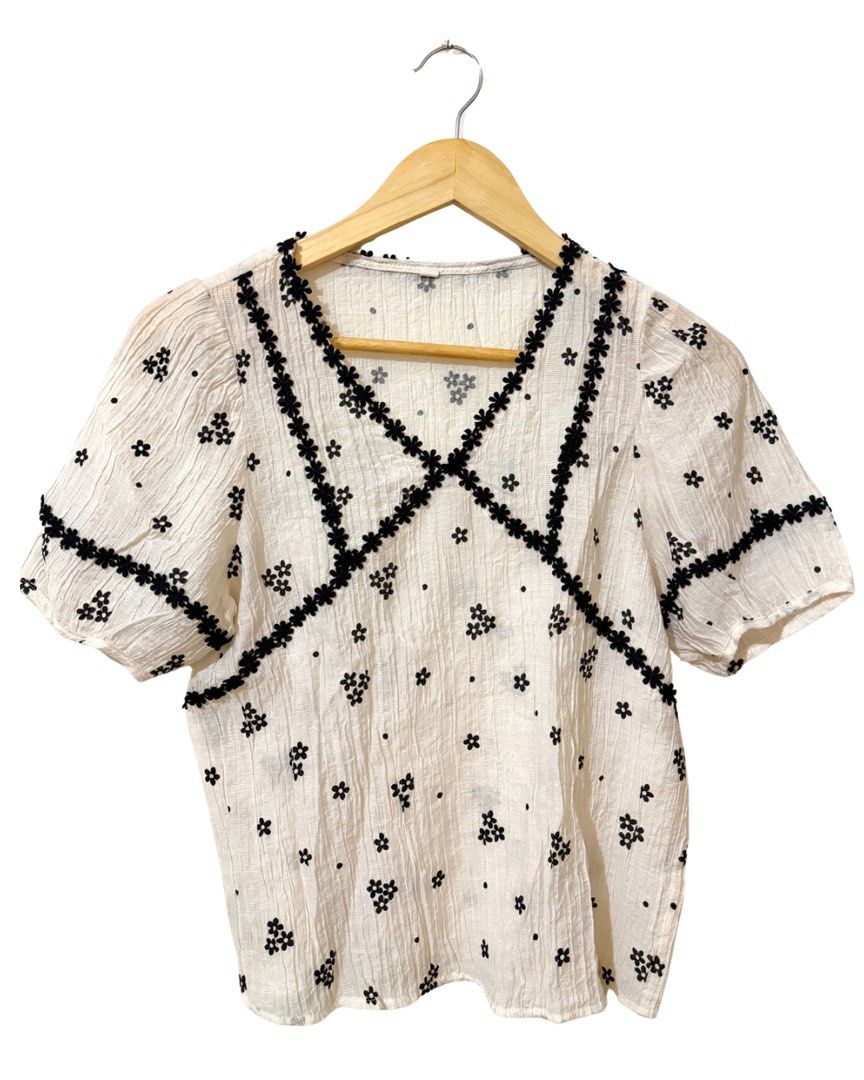 White Textured Top (Category: Blouses) located in Subic. Submitted by ciesells (Listing ID 1463147556, Image 1). Description: bust: 34 - V-neckline with black floral trim - All-over black floral and dot pattern - Perfect for casual or dressy occasions - Sheer fabric mop: bpi/maya/maribank.