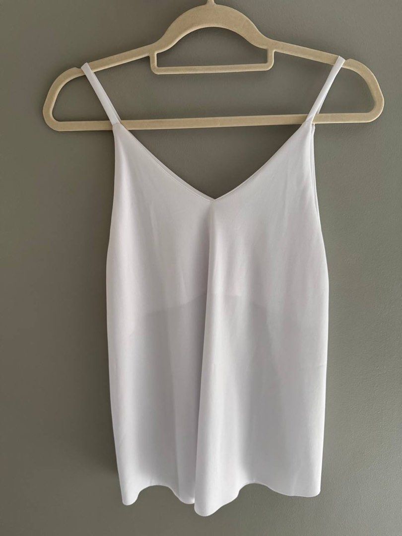 White V-neck Cami Top (Category: Sleeveless) located in Taguig. Submitted by anxmz (Listing ID 1463145228, Image 1). Description: - Simple white cami top - V-neckline with thin spaghetti straps - Lightweight fabric, drapes nicely - Perfect for layering or wearing on its own - Easy to match with any outfit - A versatile wardrobe essential.