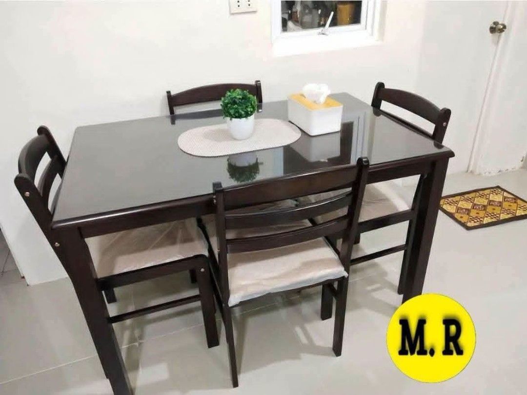 Wooden Dining Table and Chairs Set (Category: Tables & Sets) located in Quezon City. Submitted by marecel146 (Listing ID 1463119521, Image 2). Description: - Wooden dining set - Includes 1 table and 4 chairs - Chairs feature cushioned seats, still in original plastic wrap - Table has a dark wood finish - Ideal for small to medium dining areas - Simple assembly required - Pick up only.