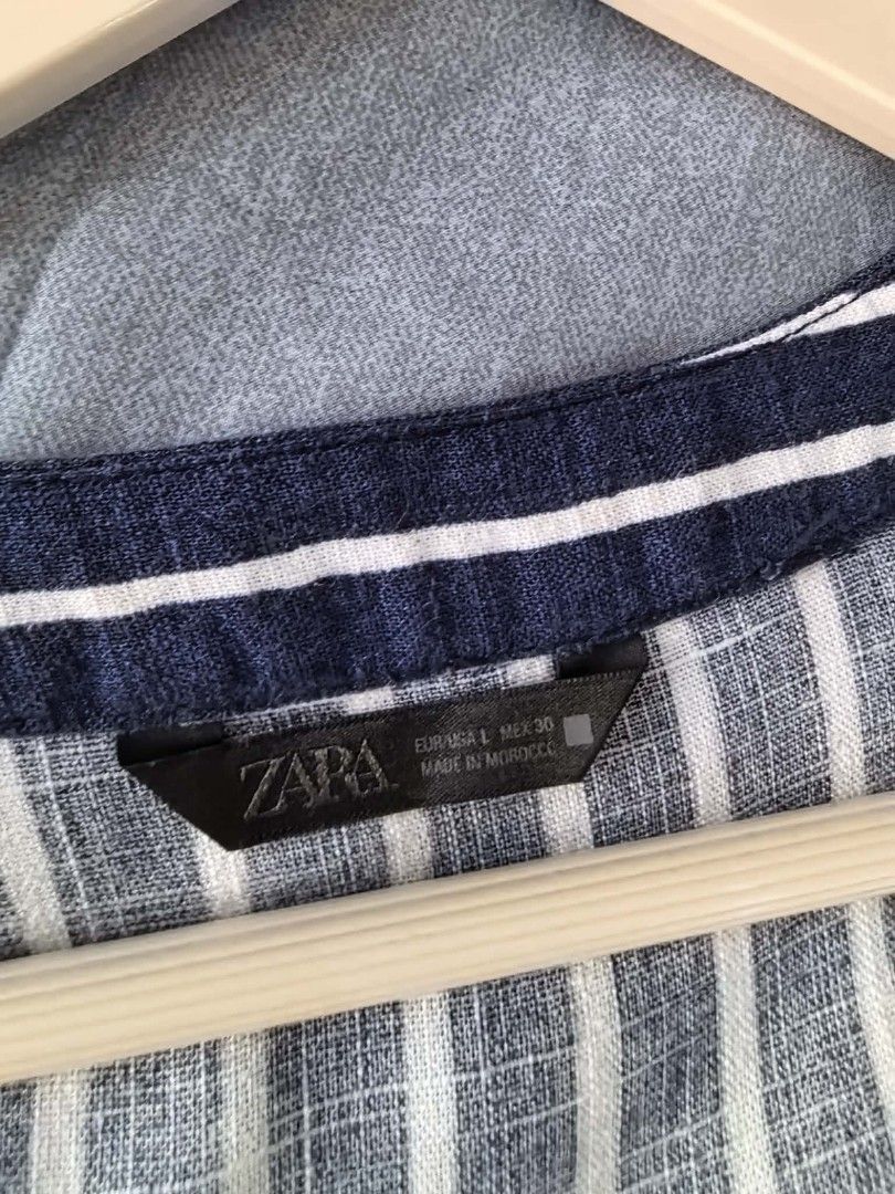 Zara Striped V-Neck Button-Up Top Size L (Category: Blouses) located in Paranaque City. Submitted by 28th_prelove (Listing ID 1463218255, Image 3). Description: - Zara navy blue and white striped top - V-neck with button-up front - Short sleeves with subtle puff detail - Pleated yoke (front and back) - High-low hemline - Size: Large (L) - Made in Morocco.