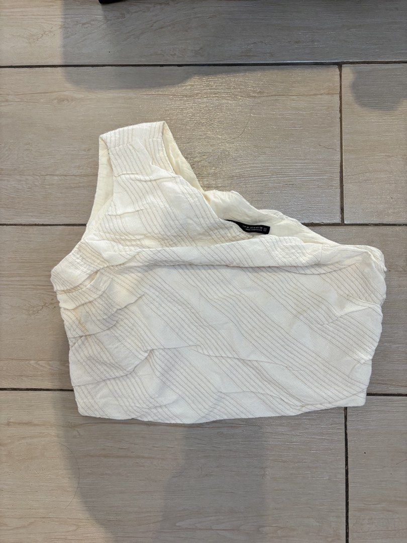 ZARA White One Shoulder Textured Top Size M (Category: Blouses) located in Paranaque City. Submitted by krispykk (Listing ID 1463187968, Image 1). Description: - ZARA white one-shoulder top - Size: Medium (M) - Fabric: Textured with subtle pinstripes - Origin: Made in Morocco - Style: Perfect for dressing up or down.