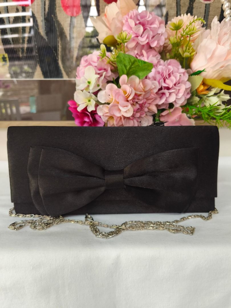 🖤 VINTAGE BLACK SATIN STATEMENT BOW EVENING CLUTCH (Category: Purses & Pouches) located in Valenzuela. Submitted by sakura_japan_surplus (Listing ID 1463358122, Image 1). Description: 🖤 VINTAGE BLACK SATIN STATEMENT BOW EVENING CLUTCH ₱280 DESCRIPTION Make an elegant statement at your next special occasion with this beautiful vintage evening clutch. Featuring a lustrous black satin finish and a striking oversized bow accent across the front fla
