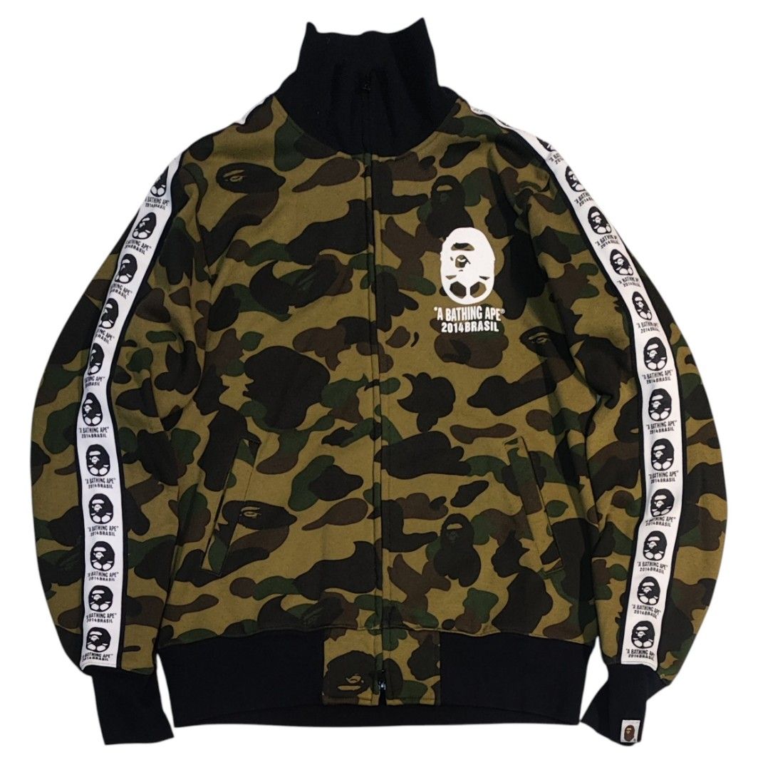 A Bathing Ape BAPE 21 Camo Track Jacket (Category: Coats, Jackets and Outerwear) located in Quezon City. Submitted by selectedandlegitgoods (Listing ID 1463539942, Image 1). Description: - Classic BAPE camo cotton track jacket - Iconic ape head logo on front - Large '21' graphic on back - Ape head tape detailing down sleeves - Ribbed collar, cuffs, and hem - Essential for any streetwear collection.