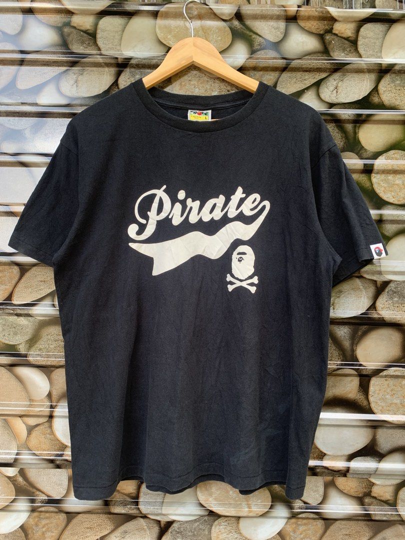 A Bathing Ape BAPE Pirate Tee L Black (Category: Tshirts & Polo Shirts ) located in Aloran. Submitted by chester78864 (Listing ID 1463491255, Image 1). Description: - Authentic Black BAPE T-Shirt - Size: Large (L) - Features a unique 'Pirate' graphic design - Includes the classic BAPE ape head logo - Sleeve tag visible for authenticity - Ideal for everyday casual wear - Great attention to detail on the graphic.