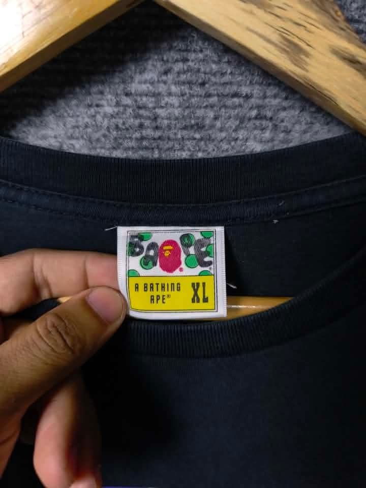A Bathing Ape BAPE Tee XL (Category: Tshirts & Polo Shirts ) located in Manila. Submitted by leandroabi09471 (Listing ID 1463355977, Image 2). Description: - Authentic A Bathing Ape (BAPE) T-shirt - Color: Black - Size: XL - Features a colorful, eye-catching ape graphic - Ideal for streetwear fashion lovers - Don't miss the intricate details on the graphic!.