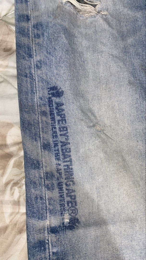 AAPE BY A BATHING APE® Jeans (Category: Jeans) located in Manila. Submitted by saintino0222 (Listing ID 1463333349, Image 3). Description: - Light wash denim jeans from AAPE BY A BATHING APE® - Signature ape head logo on coin pocket - Embroidered details on back pockets - Distressing and fading throughout for a worn-in look - Red and blue stripe detail with AAPE branding on cuffs.