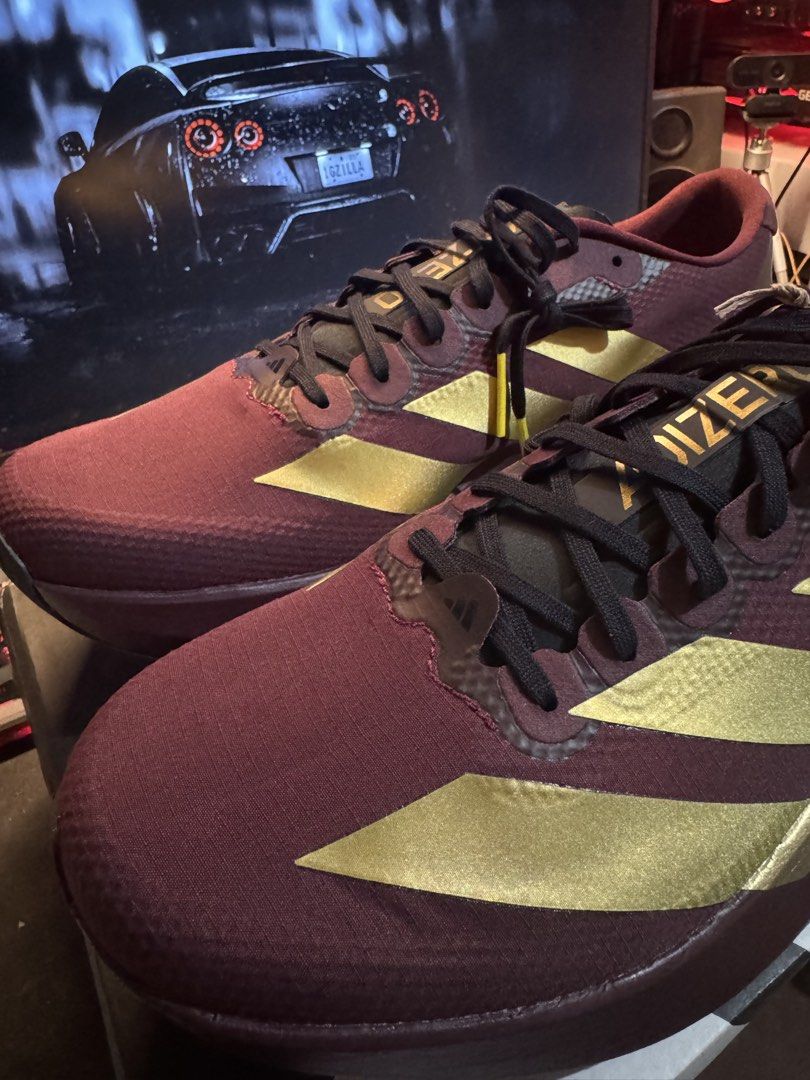 Adidas Adizero Evo SL Woven (Category: Sneakers) located in Davao. Submitted by midnightwolf07 (Listing ID 1463425928, Image 2). Description: - Maroon and gold Adidas Adizero running shoes - Lightweight design for speed - Perfect for races and training - Features black laces and gold Adidas stripes.