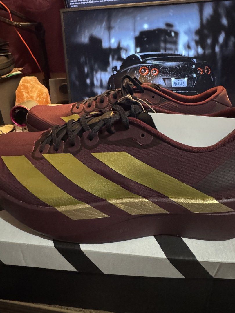 Adidas Adizero Evo SL Woven (Category: Sneakers) located in Davao. Submitted by midnightwolf07 (Listing ID 1463425928, Image 1). Description: - Maroon and gold Adidas Adizero running shoes - Lightweight design for speed - Perfect for races and training - Features black laces and gold Adidas stripes.