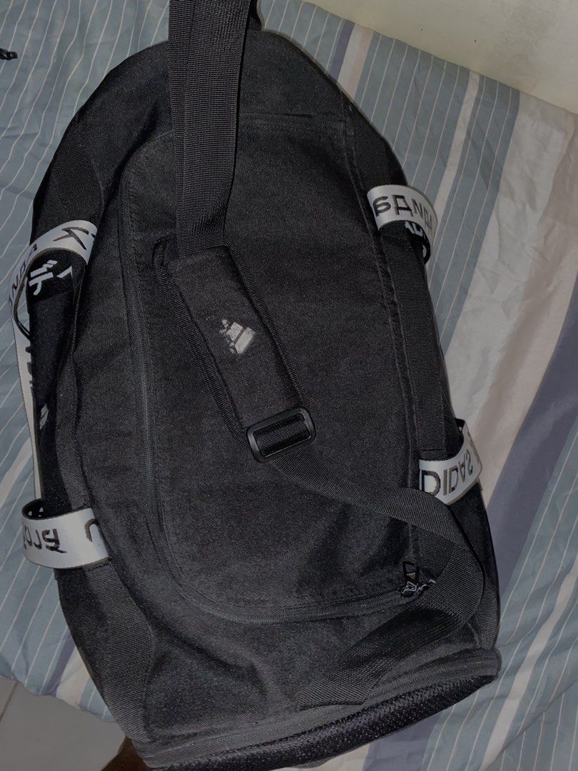 Adidas Black Duffel Bag with White Logo Strap (Category: Backpacks) located in Pasay City. Submitted by fastforest_312e97 (Listing ID 1463400279, Image 3). Description: - Black Adidas duffel bag - Main compartment for ample storage - Inner zip pocket for essentials - Adjustable strap with repeating Adidas logo - Ideal for gym sessions or short trips - Clean inside and out, ready for its new owner.