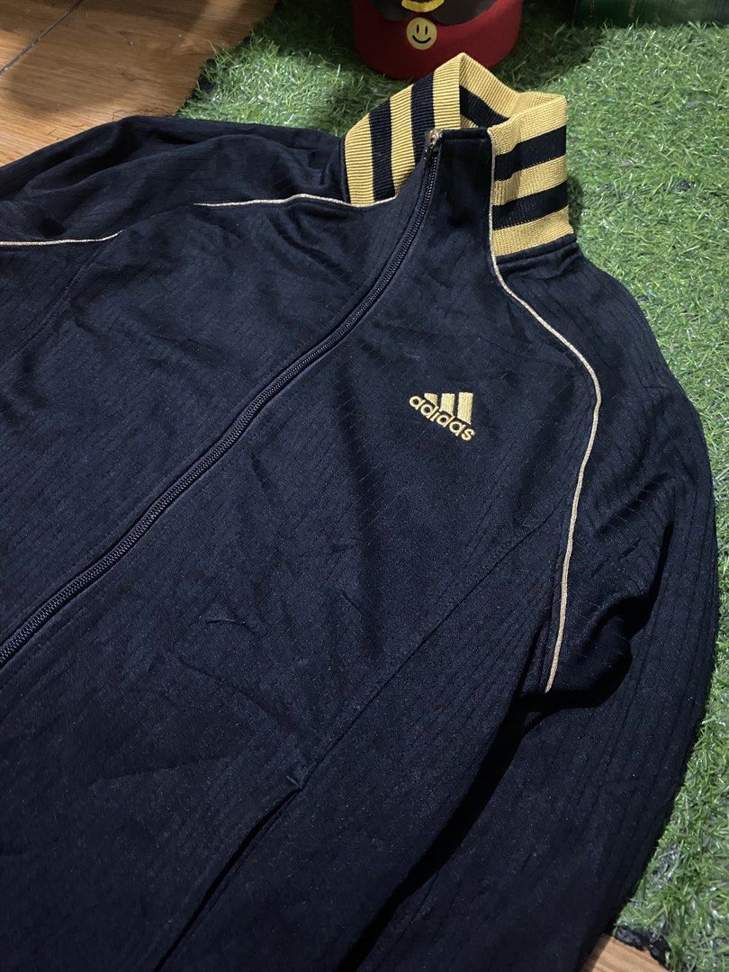 Adidas Clima365 Track Jacket Black Gold (Category: Coats, Jackets and Outerwear) located in Baguio. Submitted by pickemup2600 (Listing ID 1463498667, Image 2). Description: - Adidas track jacket in black - Size: Medium (M) - Features classic Adidas logo on chest - Ribbed collar and cuffs with gold stripes - Clima365 technology for performance - Made in China.