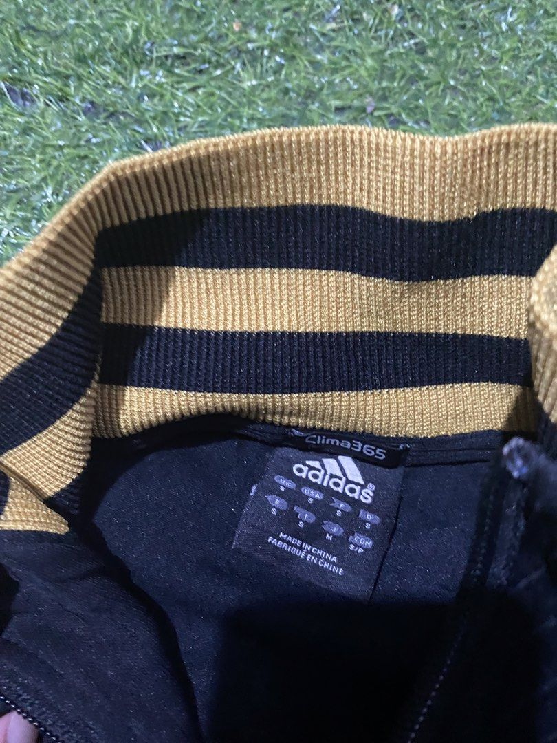 Adidas Clima365 Track Jacket Black Gold (Category: Coats, Jackets and Outerwear) located in Baguio. Submitted by pickemup2600 (Listing ID 1463498667, Image 3). Description: - Adidas track jacket in black - Size: Medium (M) - Features classic Adidas logo on chest - Ribbed collar and cuffs with gold stripes - Clima365 technology for performance - Made in China.