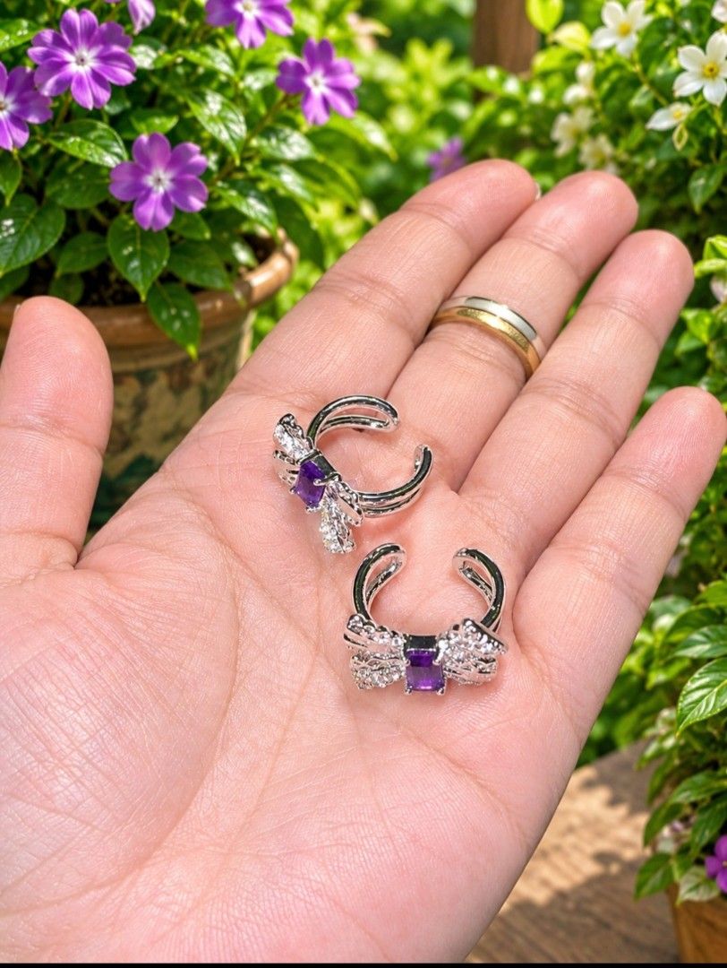 Amehtyst bow ear cuff (Category: Earrings) located in Santa Rosa. Submitted by crystal1.0 (Listing ID 1463385408, Image 1). Description: - Cute silver bow design - Features a purple square stone in the center - Accented with small clear stones for extra sparkle - Clip-on style, perfect for non-pierced ears - Sold as a pair.