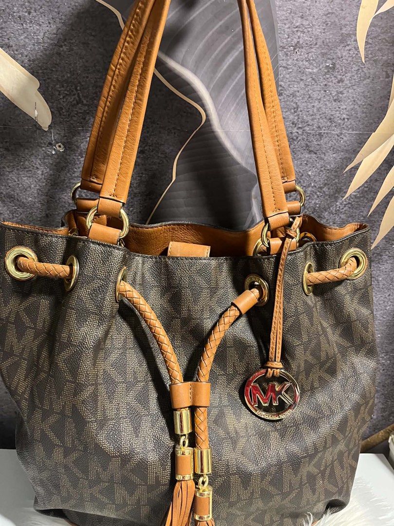 Authentic Michael Kors Jet Set Large Gathered/Drawstring Tassel Tote (Category: Shoulder Bags) located in Caloocan City. Submitted by trebdy01 (Listing ID 1463384184, Image 2). Description: AUTHENTIC MICHAEL KORS JET SET LARGE TASSELED TOTE 👜 Original from USA 🇺🇸 | Pre-owned Brown MK Signature canvas with genuine leather trim, gold-tone hardware, beautiful double tassel detail and MK medallion. Clean and well-kept, see photos for actual condit