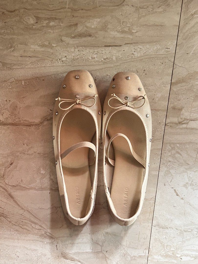 AZTRID Beige Embellished Ballet Flats with Bow (Category: Flats & Sandals) located in Kalibo. Submitted by liahrbld (Listing ID 1463486170, Image 1). Description: - Brand: AZTRID - Style: Ballet Flats - Color: Beige - Embellishments: Rhinestones and a small bow on the front - Features: Elastic strap for a secure fit, easy slip-on design - Occasion: Great for casual wear or dressing up an outfit.