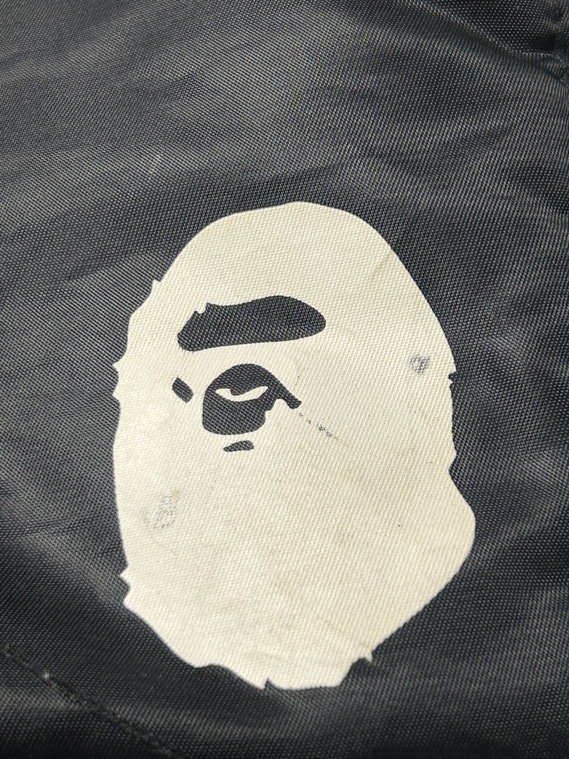 BAPE Black Tote Bag with Ape Head Logo (Category: Tote Bags) located in Tacloban City. Submitted by azthrifting24 (Listing ID 1463393428, Image 3). Description: - Authentic BAPE Black Tote Bag - Features the iconic BAPE Ape Head logo prominently on the front - Two large, convenient front pockets for quick access to essentials - Spacious main compartment offers ample storage for daily necessities or travel items - Equipped with comfortable top han