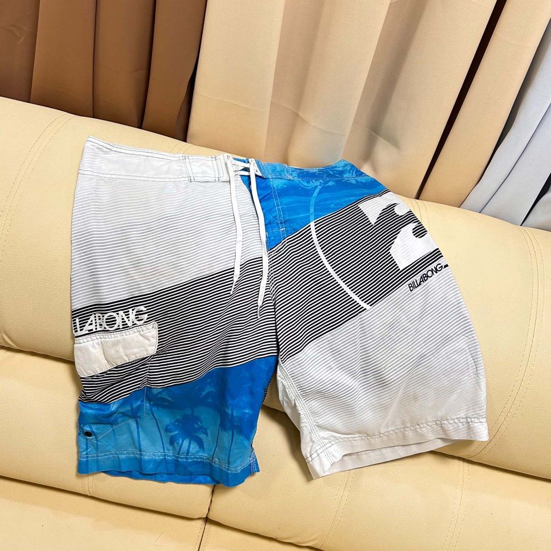 Billabong Board Shorts Size 37 (Category: Swim Trunks & Board Shorts) located in Manila. Submitted by bud_thriftt (Listing ID 1463475648, Image 1). Description: - Billabong Board Shorts - Size: 37 - Design: Cool blue and white stripes with palm tree graphics - Features: Back pocket with velcro closure, drawstring waist for adjustable comfort - Material: 100% Polyester - Ideal for: Swimming, surfing, or lounging by the beach/pool.