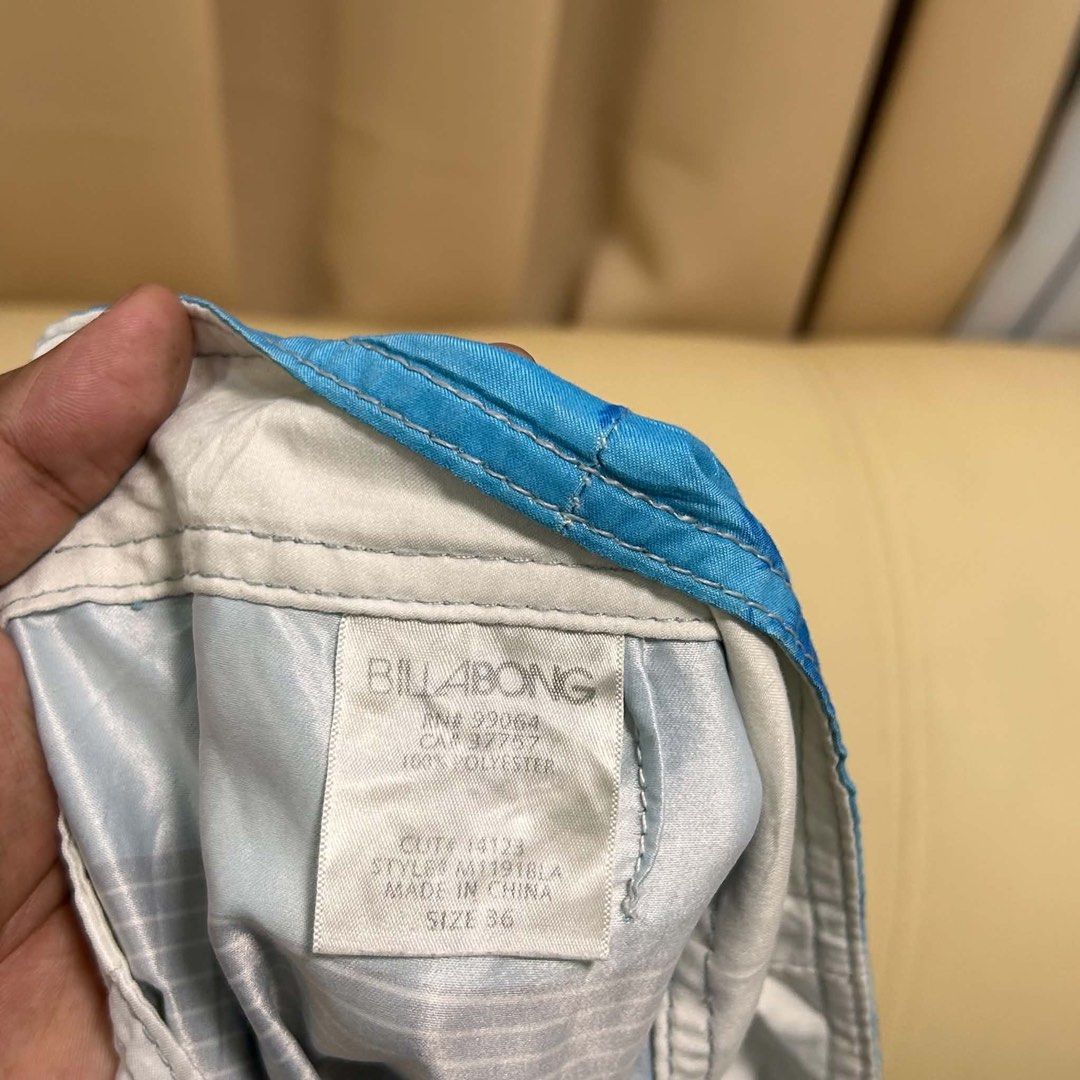 Billabong Board Shorts Size 37 (Category: Swim Trunks & Board Shorts) located in Manila. Submitted by bud_thriftt (Listing ID 1463475648, Image 3). Description: - Billabong Board Shorts - Size: 37 - Design: Cool blue and white stripes with palm tree graphics - Features: Back pocket with velcro closure, drawstring waist for adjustable comfort - Material: 100% Polyester - Ideal for: Swimming, surfing, or lounging by the beach/pool.