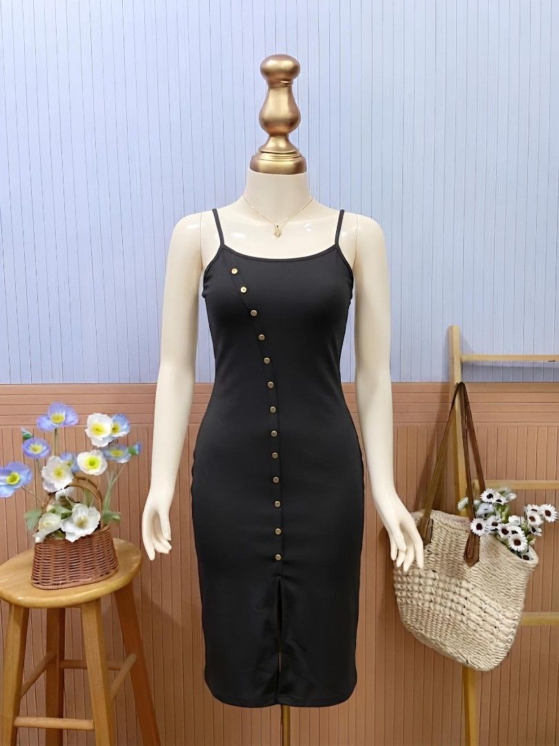 Black Asymmetric Button-Front Midi Dress (Category: Dresses) located in Roxas City. Submitted by blairnstyle (Listing ID 1463400174, Image 1). Description: Style: Bodycon midi-length slip dress featuring a sleeveless, spaghetti-strap design that hugs the silhouette. ​Key Feature: An eye-catching diagonal (asymmetric) row of decorative gold-toned buttons that curves down the front, adding a modern twist to a classic look. ​Hemline: Fitted midi cut