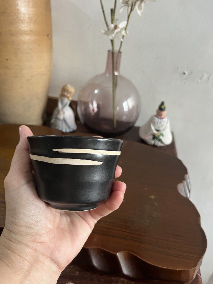 Black Ceramic Cup with White Stripes (Category: Coffee & Tea Tableware) located in Taguig. Submitted by minmin_parker (Listing ID 1463392719, Image 3). Description: - Small black ceramic cup - Features thin white stripes around the top - Ideal for tea or sake - Unique design - Approximately 3 inches tall - Great for small drinks or as a decorative piece - Please check photos for detailed condition.