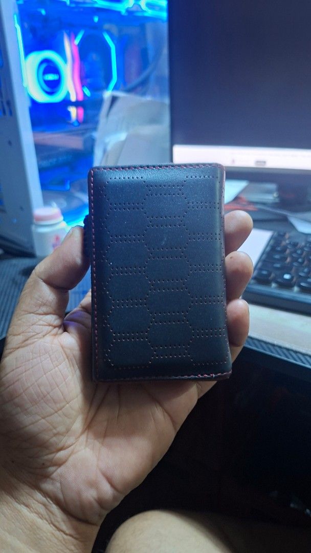 Black Leather Card Holder Wallet with Red Stitching (Category: Wallets & Card holders) located in Caloocan City. Submitted by mackulitzz36892 (Listing ID 1463397540, Image 2). Description: - Slim black leather card holder - Textured hexagon pattern on front - Red stitching detail - Interior card slots - Built-in metal card dispenser - Includes original box - Compact and stylish for daily use.