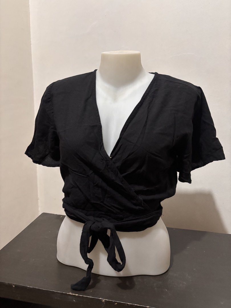Black wrap top with tie detail (Category: Blouses) located in Manila. Submitted by youngstorm-2021 (Listing ID 1463358080, Image 1). Description: - Cute black wrap top - Short sleeves with tie detail - Flattering V-neckline - Easy to style for any occasion - Perfect with jeans or skirts.