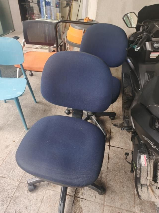 Blue Fabric Office Chair with Wheels (Category: Office Furniture & Fixtures) located in San Pedro. Submitted by cgi.saversplustrading (Listing ID 1463347553, Image 2). Description: - Comfortable blue fabric office chair - Swivel base with wheels for easy mobility - Slightly curved backrest for ergonomic support - Ideal for home or office settings - Shows minor signs of wear but is fully functional.