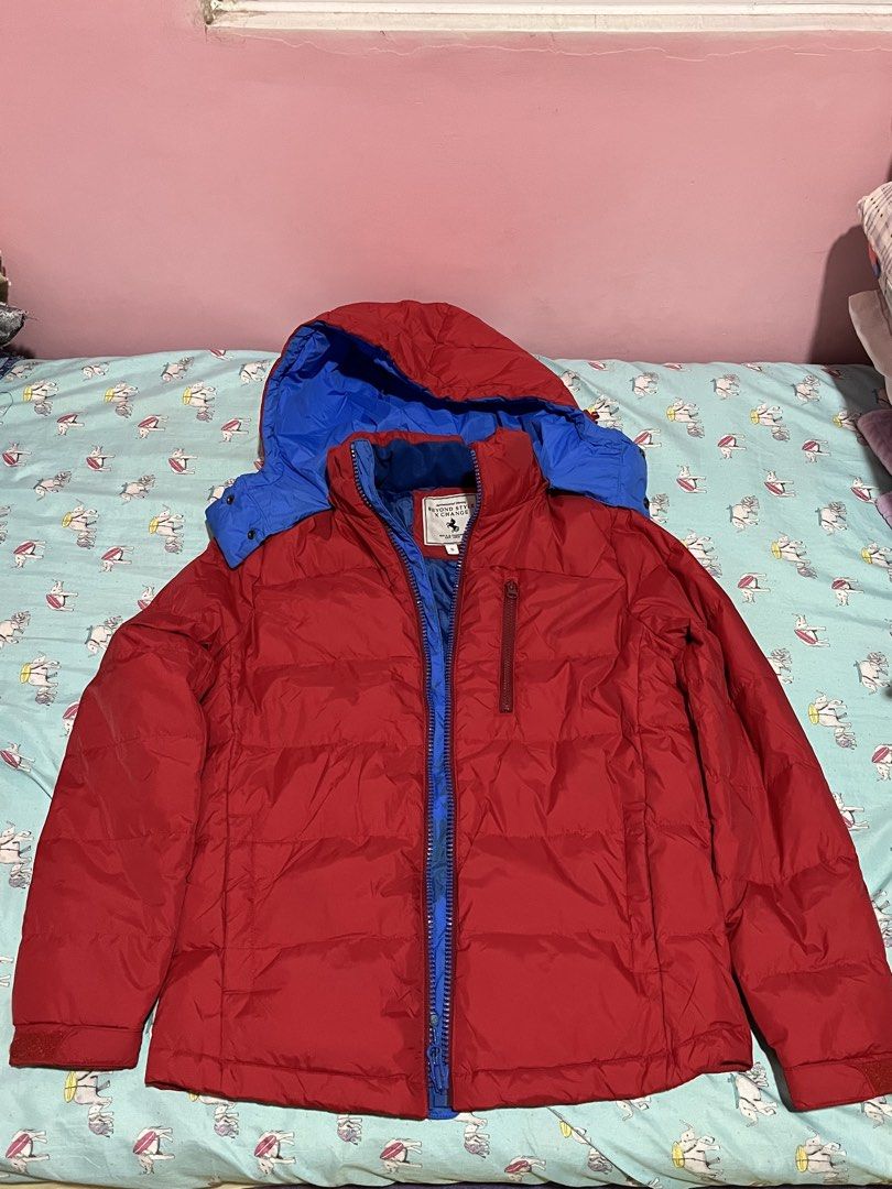 BSX Red & Blue Hooded Puffer Jacket (Category: Coats, Jackets and Outerwear) located in Dasmarinas. Submitted by gmxngmmd (Listing ID 1463528168, Image 3). Description: BSX Red & Blue Hooded Puffer Jacket - Red and blue puffer jacket with hood - Zip-up front with chest pocket - Excellent for warmth - Perfect for everyday wear or outdoor adventures - Easy to pack and carry Size: Small Length: 26 inches Chest: 20 inches Shoulder: 16.5 inches Arm Le
