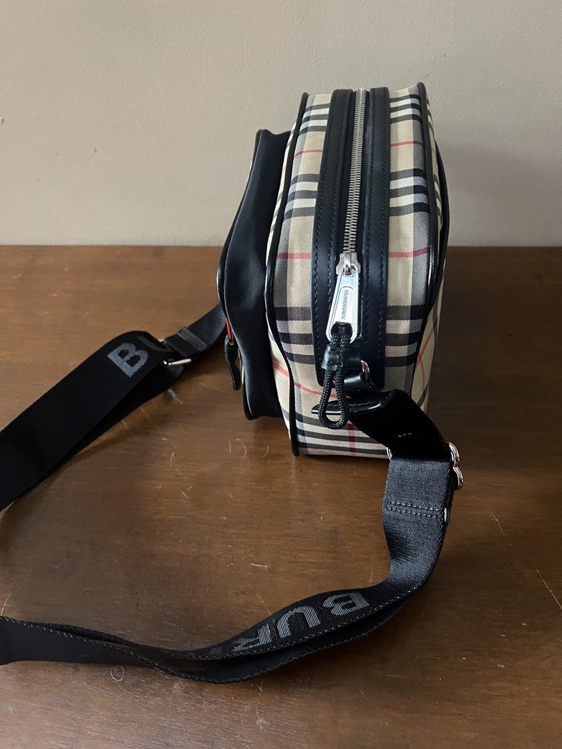 Burberry Nova Check Crossbody Bag with Logo Strap (Category: Luxury Bags & Wallets) located in Taguig. Submitted by leticia_123 (Listing ID 1463342662, Image 2). Description: - Authentic Burberry Nova Check crossbody bag - Classic nova check pattern with black leather trim - Adjustable strap with embossed Burberry logo - Main zip compartment for secure storage - Additional front zip pocket for quick access - Interior tags visible, confirming auth