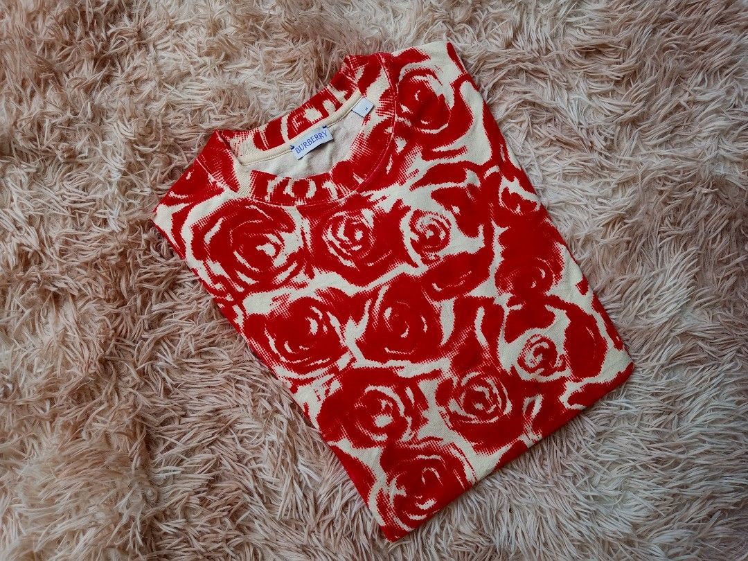 Burberry Rose Print T-Shirt (Category: Tshirts & Polo Shirts ) located in Boston. Submitted by johnpaulvi30029 (Listing ID 1463402428, Image 2). Description: - Authentic Burberry tee - Cream base with vibrant all-over red rose print - Short sleeves and crew neck - Perfect statement piece for any outfit - Versatile for dressing up or down.