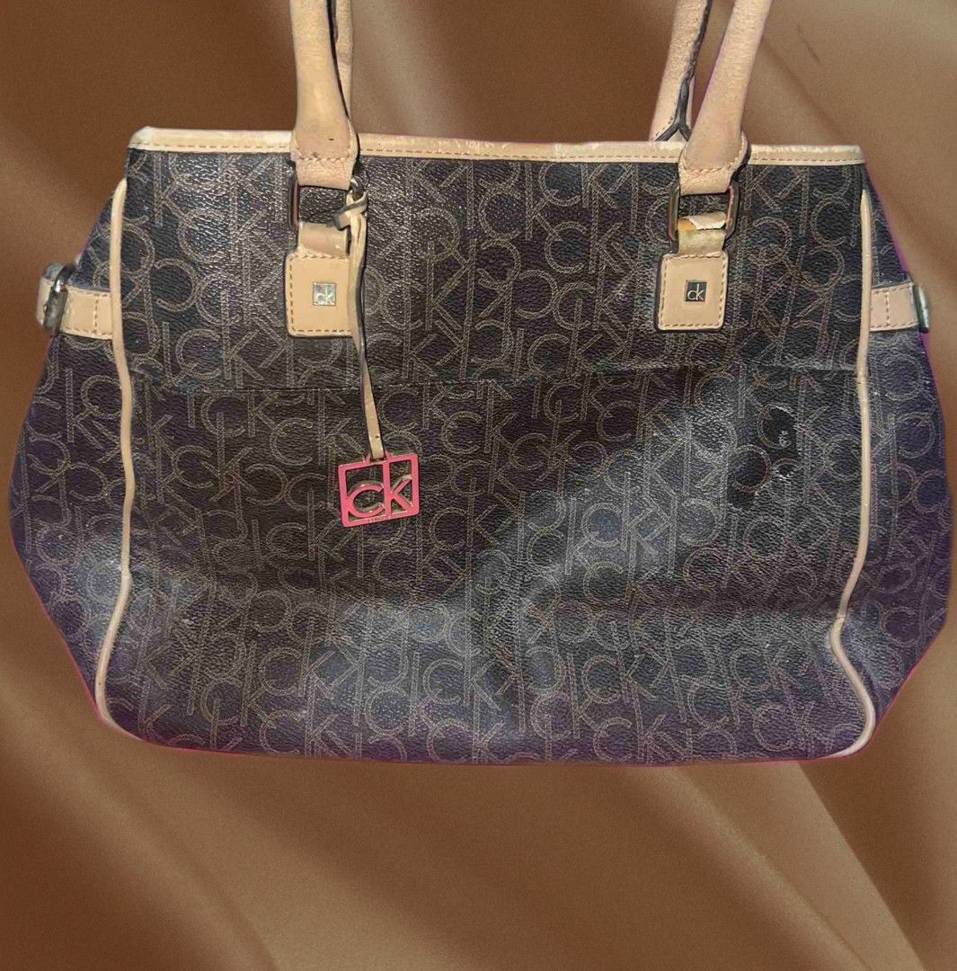 Calvin Klein Brown Tote Bag (Category: Tote Bags) located in Rizal. Submitted by youngpenguin.ae303d (Listing ID 1463357966, Image 1). Description: Decluttering Note: This bag has visible signs of use, as shown in the photos. Minor scratches and marks are visible..