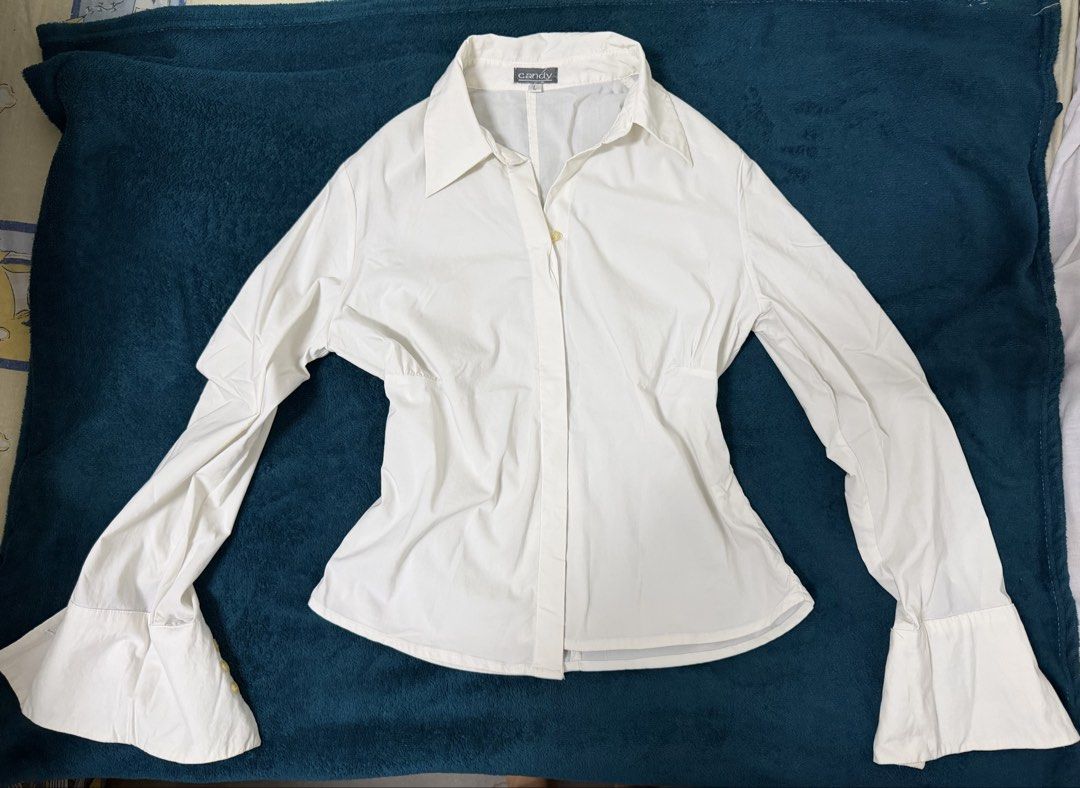 Candy White Button-Up Shirt with Bell Sleeves (Category: Shirts) located in Quezon City. Submitted by baguetteparangkasalananko (Listing ID 1463452180, Image 1). Description: - Brand: Candy - Color: White - Style: Button-up shirt - Fit: Fitted waist - Sleeves: Dramatic bell sleeves - Estimated Size: L - Versatility: Perfect for dressing up or down, pairs well with jeans or skirts..