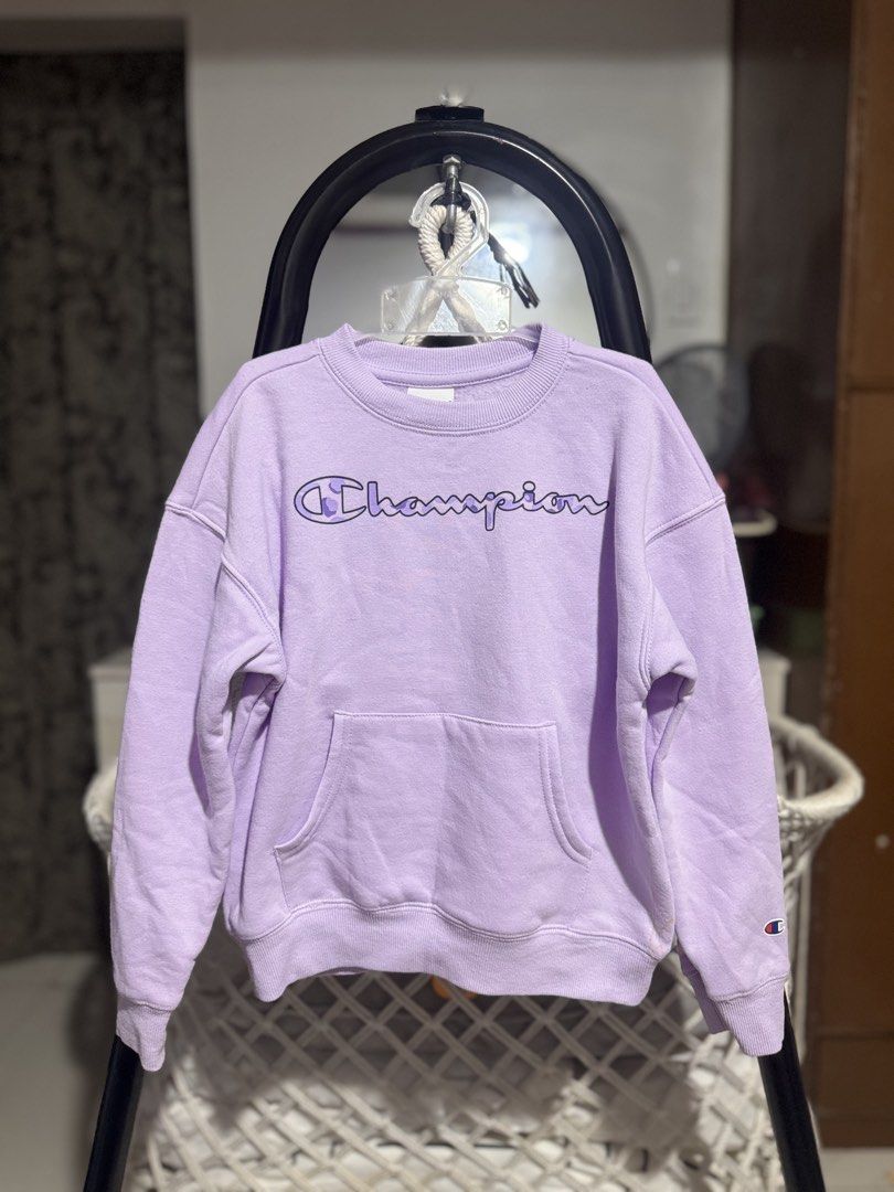 Champion Lavender Crewneck Sweatshirt (Category: Babies & Kids Fashion) located in Santa Rosa. Submitted by yasss23 (Listing ID 1463356368, Image 1). Description: - Cute lavender Champion sweatshirt - Classic Champion logo on front - Features a kangaroo pocket - Small stain on the right cuff (see last photo) 6T.