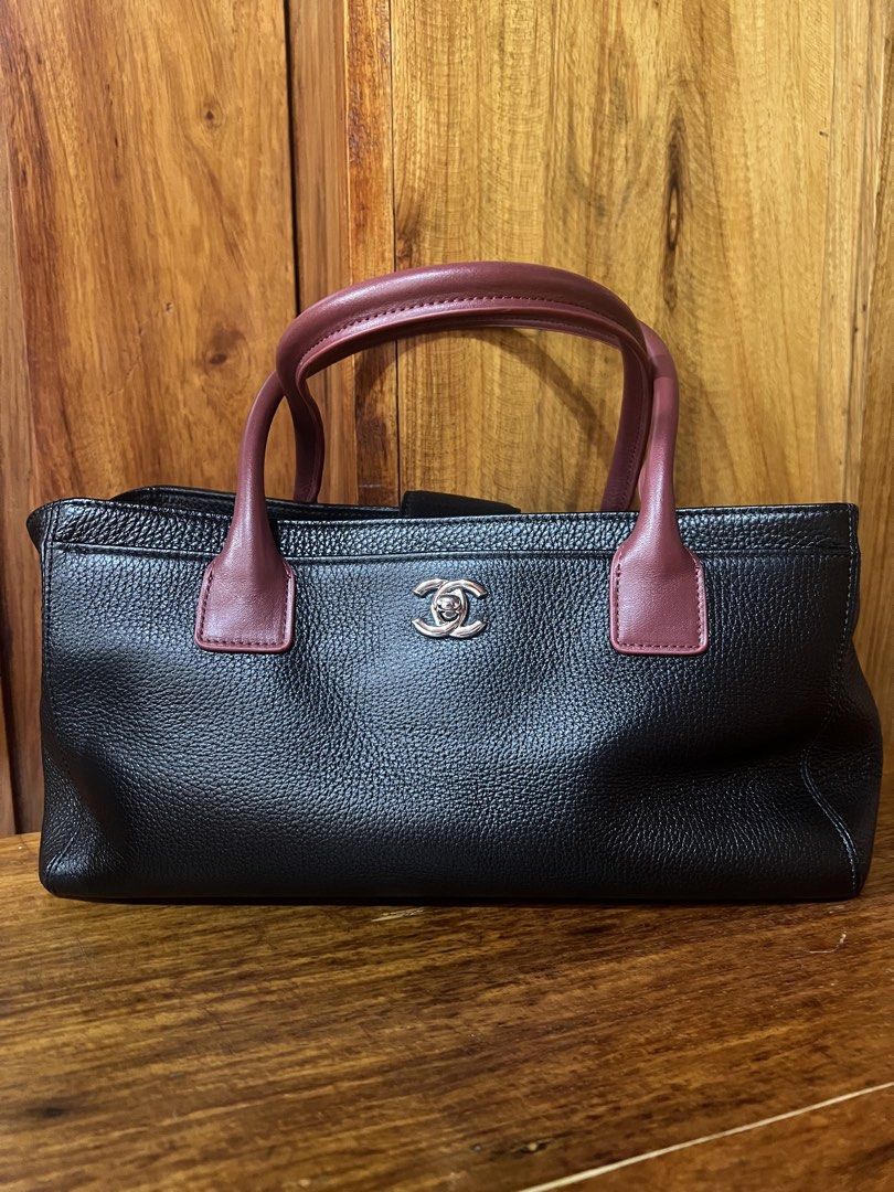 Chanel Cerf East West Tote (Category: Luxury Bags & Wallets) located in Baguio. Submitted by Passionista_2600 (Listing ID 1463554587, Image 1). Description: - Classic black leather tote bag - Burgundy leather top handles -3 compartments with detachable pouch inside - Silver hardware details, hexa screw, chanel underzip and puller - Protective studs on the bottom - Spacious and stylish for everyday use -L12.2in x H6.7in x W5.3in -comes with dustba