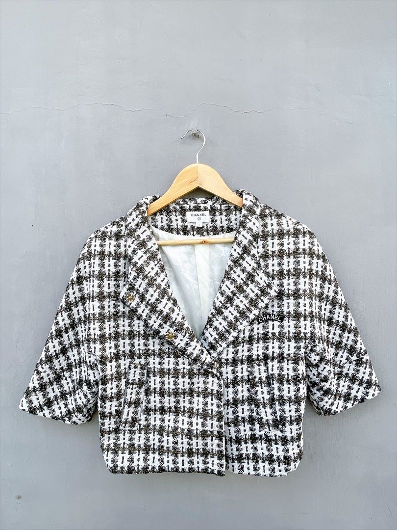 Chanel Tweed Cropped Jacket (Category: Coats, Jackets and Outerwear) located in San Nicolas. Submitted by .luxfinds_0222 (Listing ID 1463330841, Image 1). Description: Size: Medium Width :19 Length :20 CR:10/10 Issue :NONE - Classic Chanel tweed jacket - Color: Black, white, and gold pattern - Style: Cropped with short sleeves - Features: Iconic Chanel logo patch on lapel - Interior: Fully lined - Closure: Button - Size: M - Perfect for fashion e