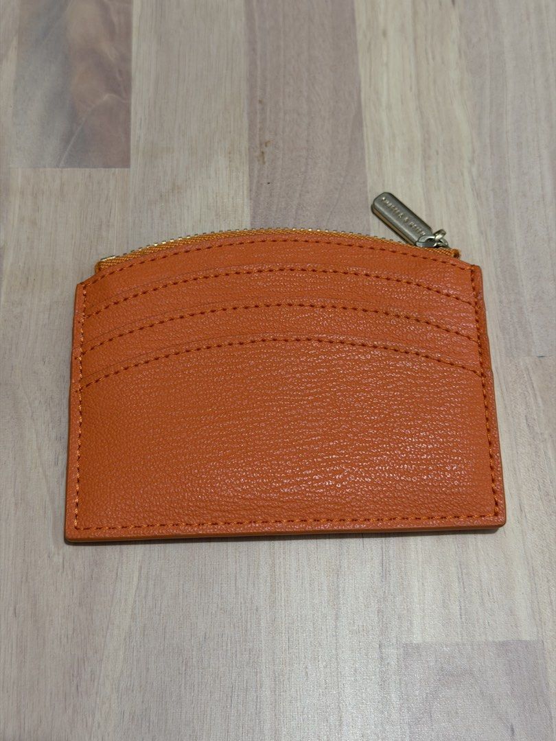 Charles & Keith Orange Cardholder with Zipper (Category: Wallets & Card holders) located in Manila. Submitted by emchi19 (Listing ID 1463530029, Image 2). Description: - Brand: Charles & Keith - Color: Orange - Features: Multiple front card slots - Additional compartment: Zippered pocket for coins or small items - Design detail: Embossed brand name on the front - Overall: Bright and functional.