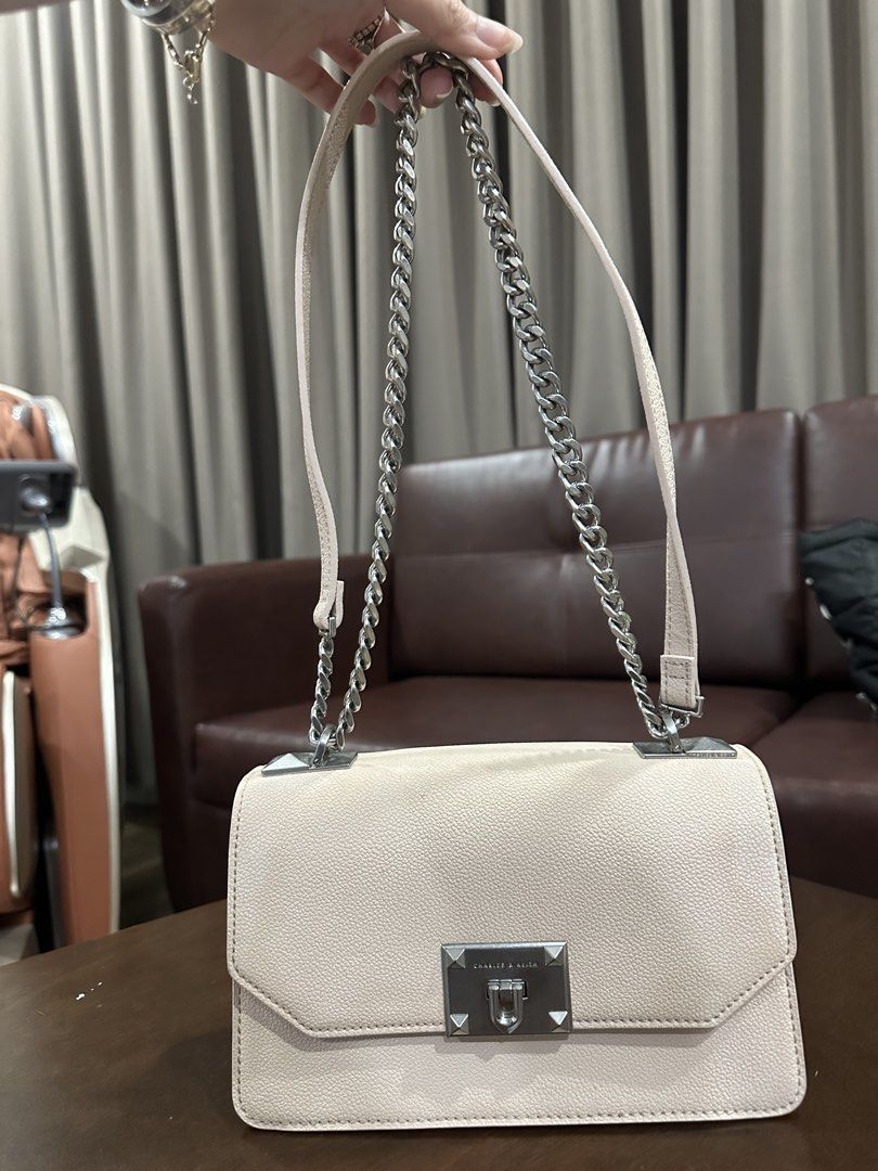 Charles & Keith Shoulder Bag (Category: Shoulder Bags) located in Davao. Submitted by secondlife.authentic (Listing ID 1463478561, Image 1). Description: - Light pink shoulder bag from Charles & Keith - Features a stylish silver chain strap - Secure turn-lock closure - Beautiful textured leather finish - Ample space for your essentials - Versatile for casual or dressed-up looks -Minor Stain/Discoloration.