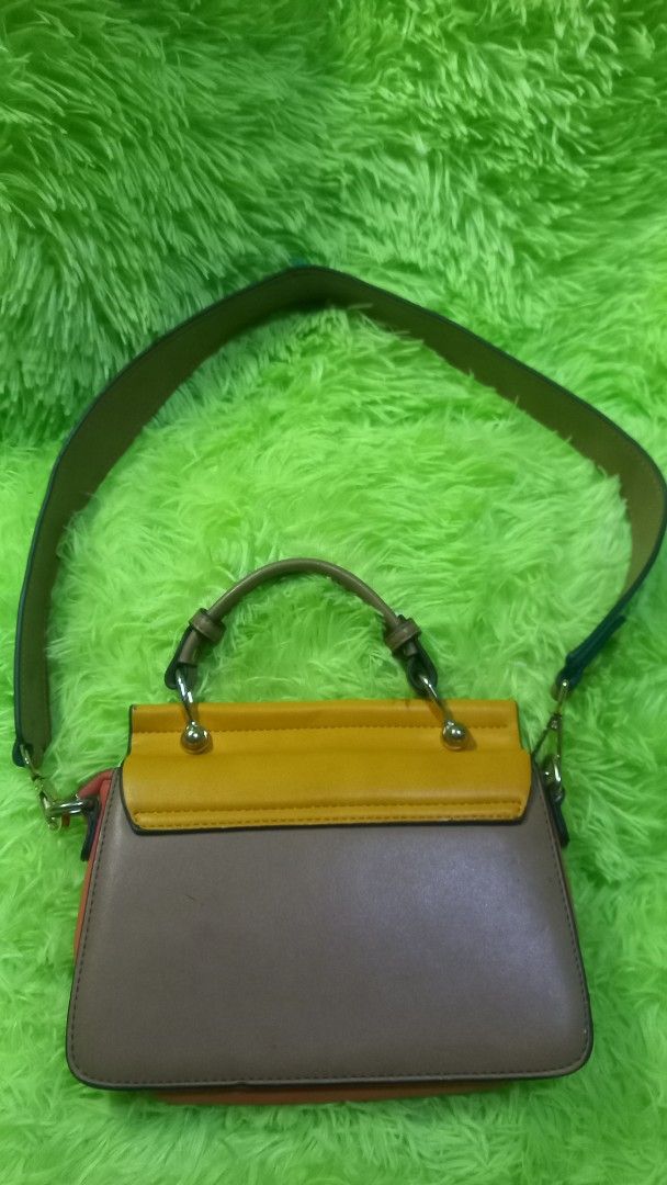 Chleo Small Handbag Shoulder Bag (Category: Luxury Bags & Wallets) located in Manila. Submitted by twinklelyn03 (Listing ID 1463388915, Image 2). Description: - Stylish Chleo handbag - Mix of brown and yellow leather - Elegant gold ring detail on front flap - Vibrant coral-colored interior - Multiple compartments for organization - Includes a long, adjustable strap - Ideal for everyday wear see photos for details pm sa sure buyer only thank you s