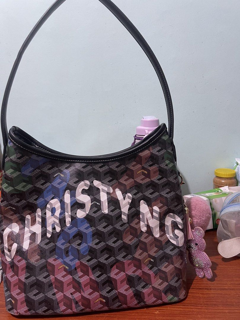 Christy Ng Monogram Shoulder Bag (Category: Shoulder Bags) located in Manila. Submitted by esmhieraiks (Listing ID 1463347515, Image 3). Description: - pre loved Authentic Christy Ng shoulder bag - Signature monogram pattern with 3D cube effect (green, blue, pink) - 'CHRISTY NG' name prominently displayed on the front - Comes with a black strap Complete with dust bag - Includes a cute tassel charm - Ideal for everyday wear.