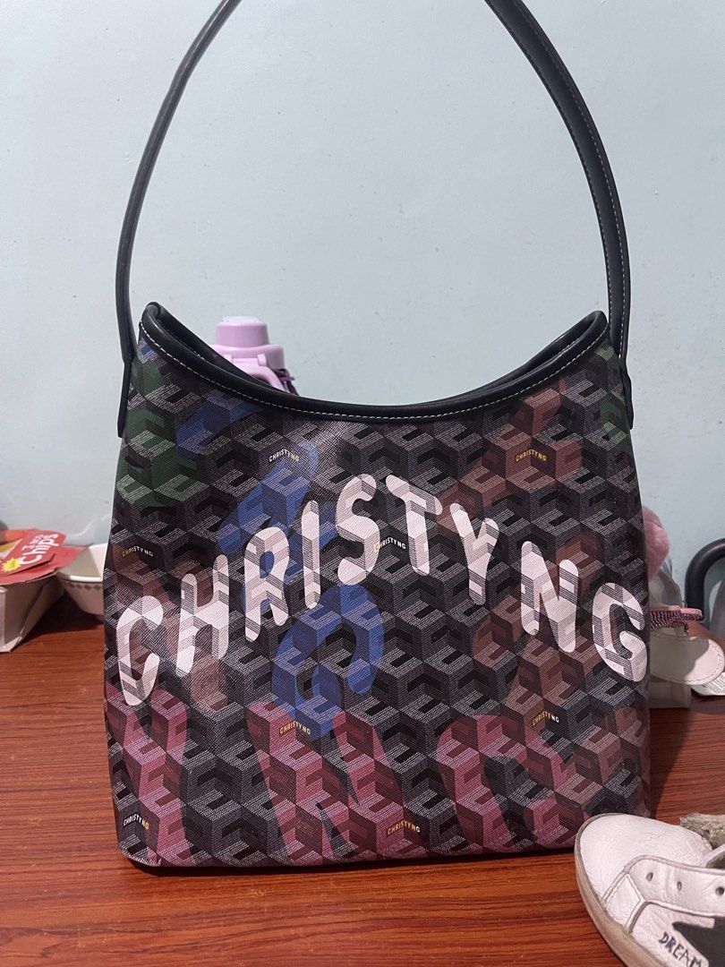 Christy Ng Monogram Shoulder Bag (Category: Shoulder Bags) located in Manila. Submitted by esmhieraiks (Listing ID 1463347515, Image 2). Description: - pre loved Authentic Christy Ng shoulder bag - Signature monogram pattern with 3D cube effect (green, blue, pink) - 'CHRISTY NG' name prominently displayed on the front - Comes with a black strap Complete with dust bag - Includes a cute tassel charm - Ideal for everyday wear.
