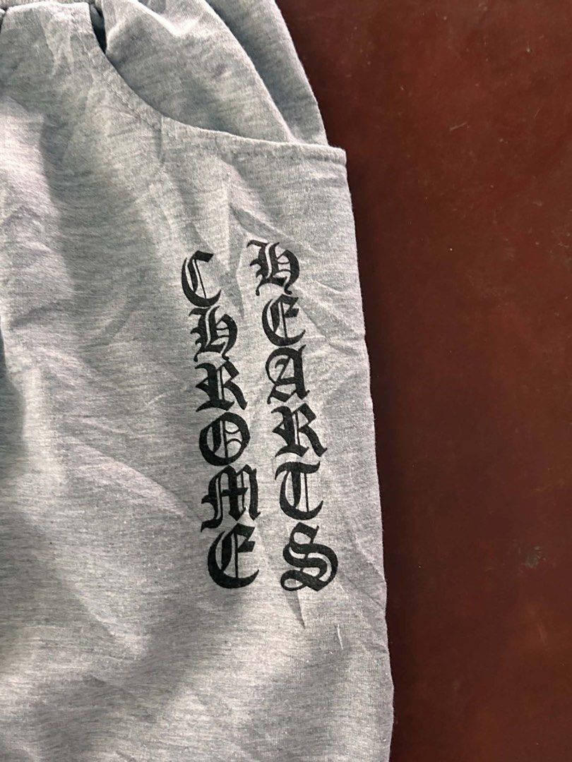 Chrome Hearts Grey Sweatpants (Category: Joggers) located in Manila. Submitted by bud_thriftt (Listing ID 1463398052, Image 2). Description: - Grey sweatpants with iconic Chrome Hearts logo on the side. - Stylish star graphics running down the leg. - Unique cross design featured on the back pocket. - Comfortable elastic waistband with adjustable drawstring. - Finished with cuffed ankles for a snug fit. - Designed for a comfortable and relaxed fit