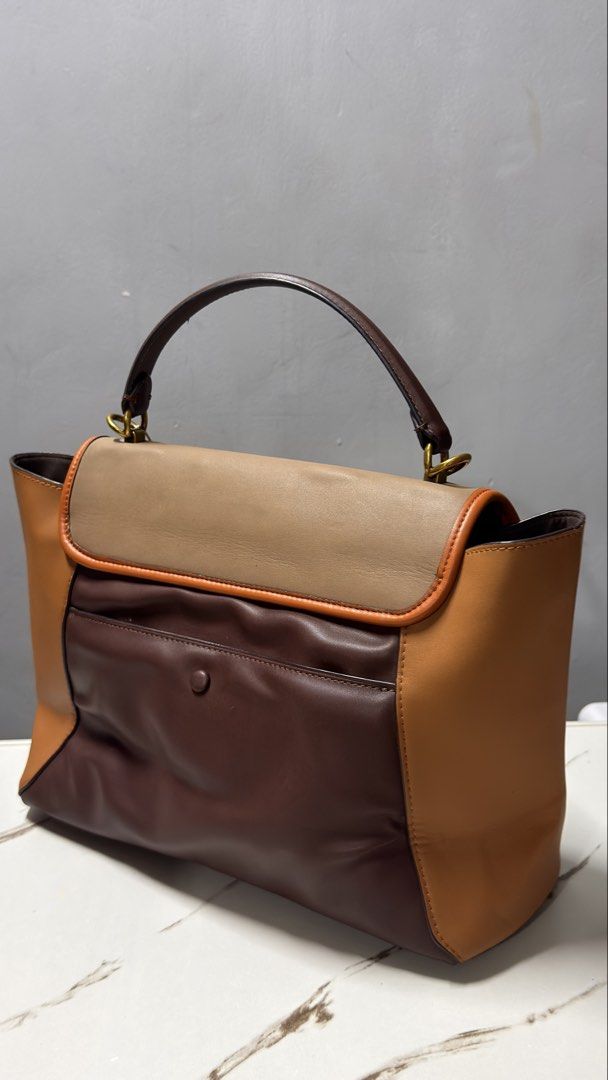 Coach Brown Leather Handbag with Gold Hardware (Category: Luxury Bags & Wallets) located in Manila. Submitted by faye_preloved (Listing ID 1463340342, Image 3). Description: - Classic brown leather handbag - Tan accent details - Gold zipper closure - Gold hardware - Visible interior lining - Versatile for everyday or special occasions - Comes with original packaging inside.