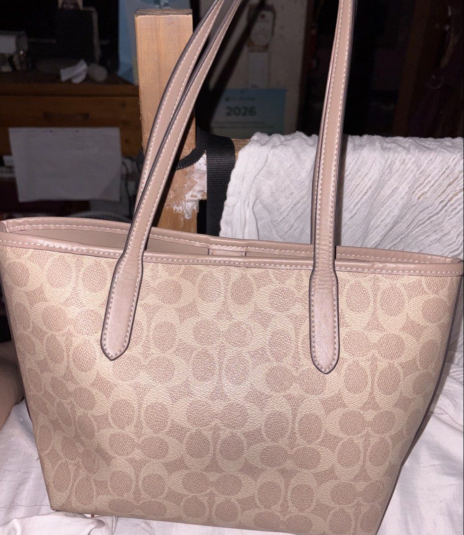Coach City Tote Bag Beige (Category: Luxury Bags & Wallets) located in Taguig. Submitted by prelovedbydein (Listing ID 1463501384, Image 2). Description: - NGA Coach tote bag (u need to legit check if maselan) - Signature beige print with tan leather trim and handles - Interior zip pocket and slip pockets - Includes Coach hangtag - Ideal for everyday use.